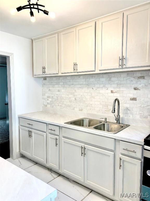 644 Iris Ln, Montgomery, AL 36105 - kitchen featuring light marble finish floors, a sink, light countertops, and tasteful backsplash