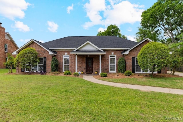 view of front of property featuring a shingled roof, brick siding, and a front lawn