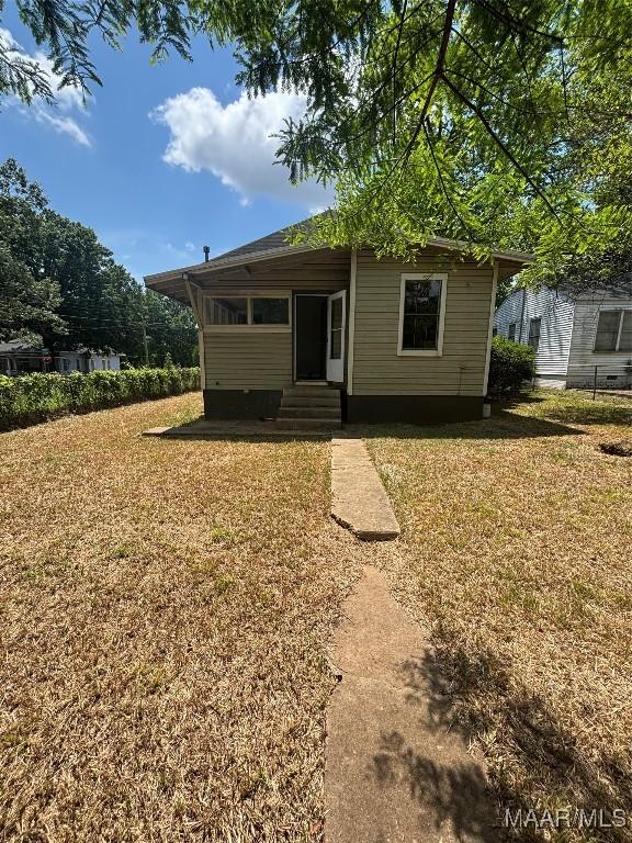 back of property with a yard and entry steps