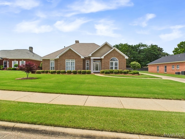 ranch-style house with a chimney, brick siding, and a front lawn