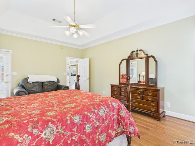 bedroom featuring crown molding, visible vents, baseboards, light wood-type flooring, and a ceiling fan