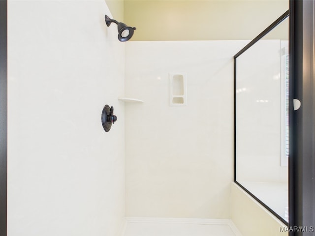 bathroom featuring a shower and baseboards