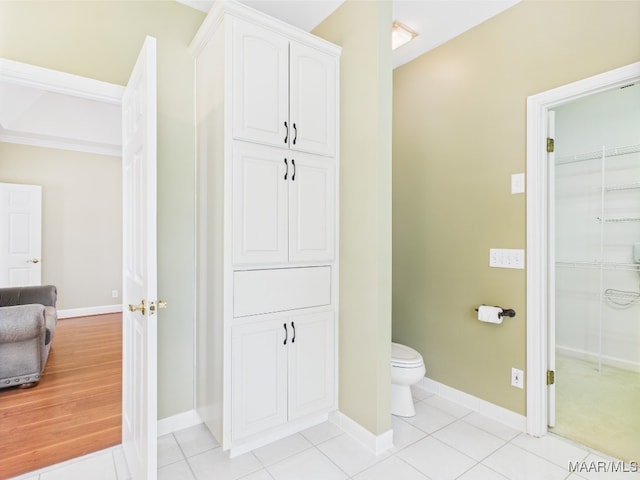 bathroom featuring tile patterned floors, toilet, and baseboards