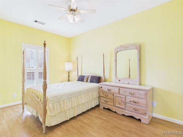 bedroom with light wood finished floors, visible vents, ceiling fan, and baseboards