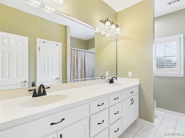 full bath with tile patterned floors, visible vents, double vanity, and a sink