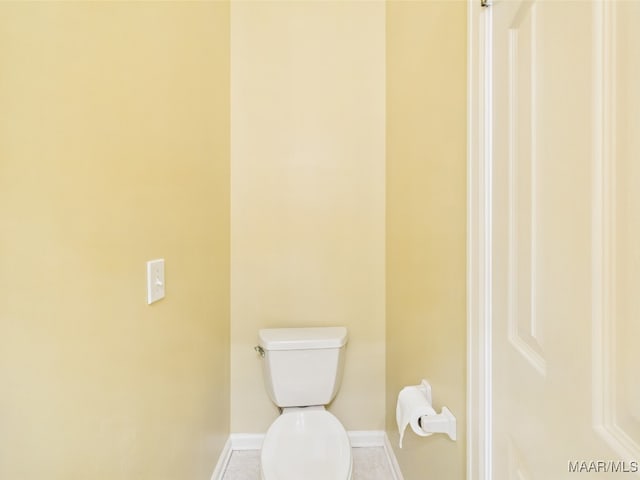 bathroom with toilet, tile patterned flooring, and baseboards