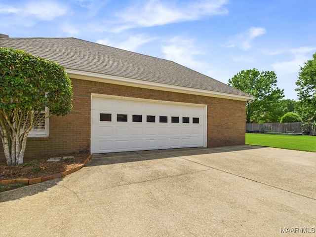 garage with fence and concrete driveway