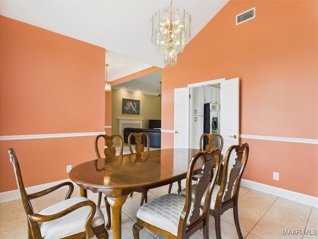 dining area with baseboards, visible vents, light tile patterned floors, and a fireplace