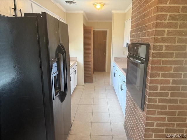 3244 Cheltenham Dr, Montgomery, AL 36116 - kitchen featuring light tile patterned flooring, crown molding, black appliances, white cabinetry, and light countertops