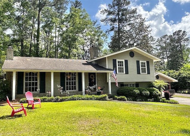 tri-level home featuring a porch, a front yard, and a chimney