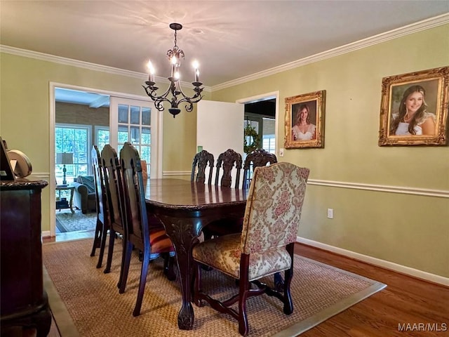 dining area featuring crown molding, an inviting chandelier, wood finished floors, and baseboards