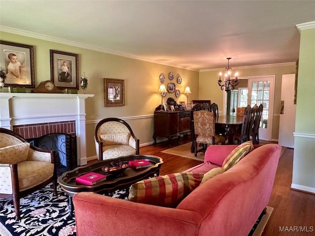 living room with crown molding, an inviting chandelier, wood finished floors, and a fireplace