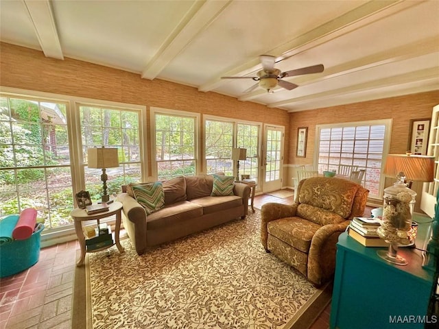 interior space with a ceiling fan, brick floor, and beam ceiling