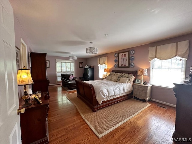 bedroom featuring baseboards, wood finished floors, and ceiling fan