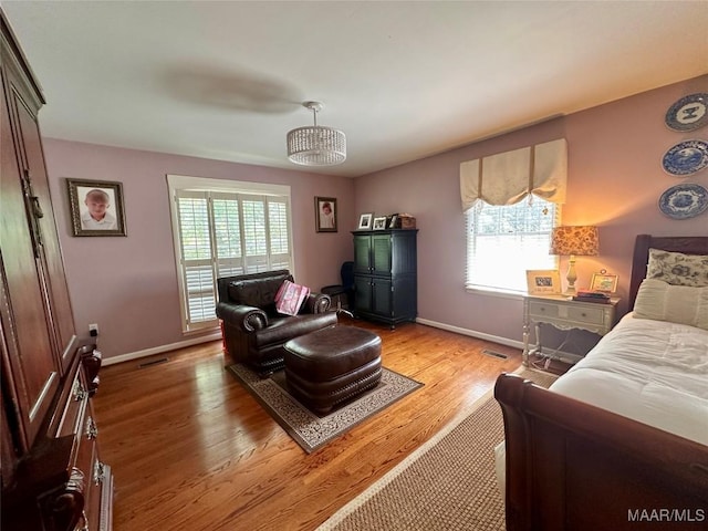 living area with baseboards, a healthy amount of sunlight, and light wood-style flooring