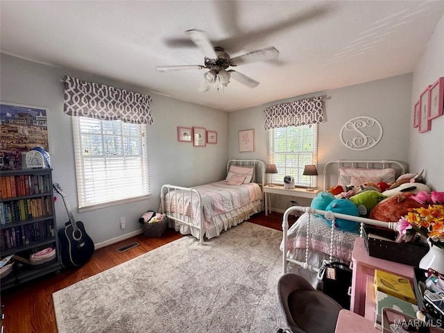 bedroom featuring ceiling fan, wood finished floors, and baseboards