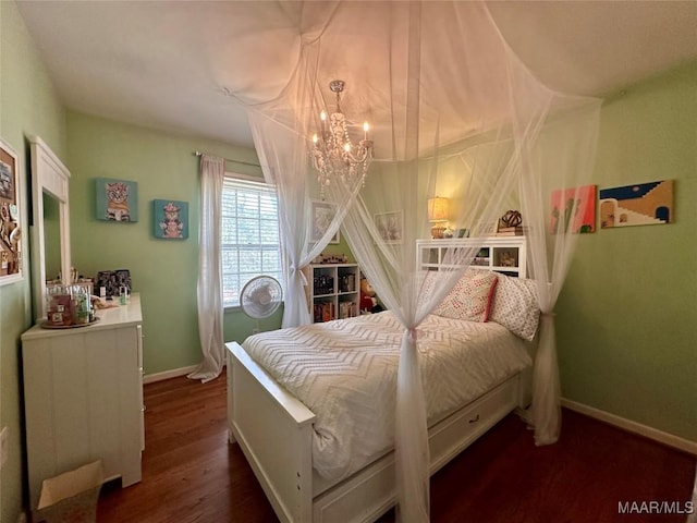bedroom with an inviting chandelier, wood finished floors, and baseboards