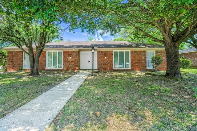 ranch-style home featuring a front lawn and brick siding
