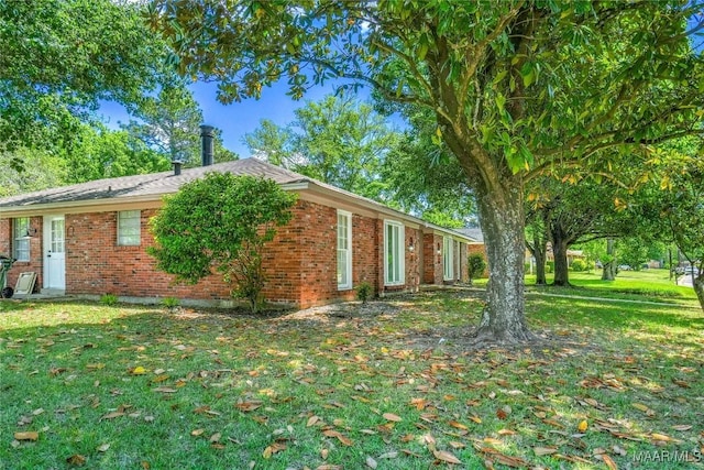 exterior space featuring a yard and brick siding