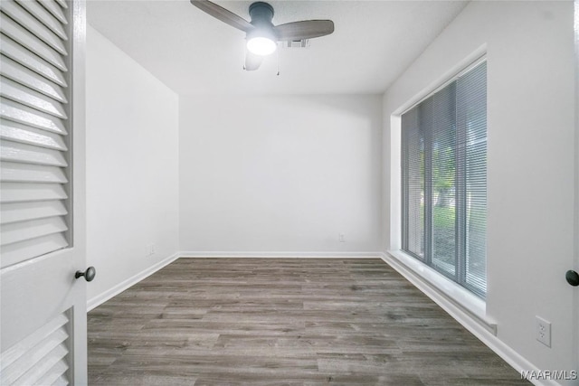 empty room featuring baseboards, wood finished floors, and a ceiling fan