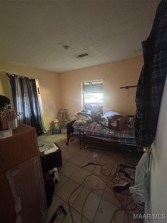 bedroom featuring light tile patterned floors and visible vents