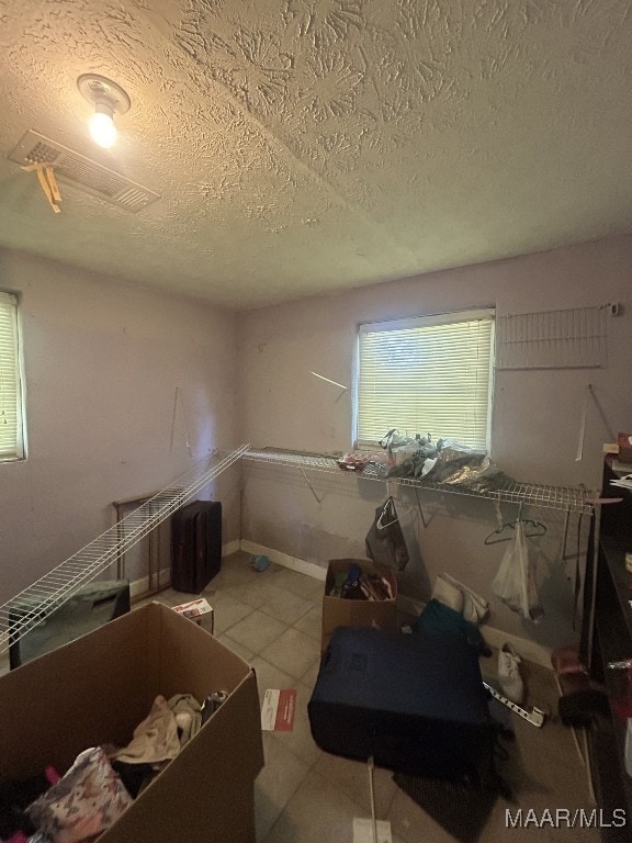 interior space featuring a textured ceiling and tile patterned flooring