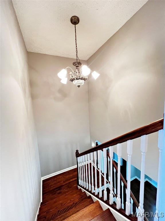733 Cartwright Rd, Titus, AL 36080 - stairway featuring an inviting chandelier, wood finished floors, and baseboards
