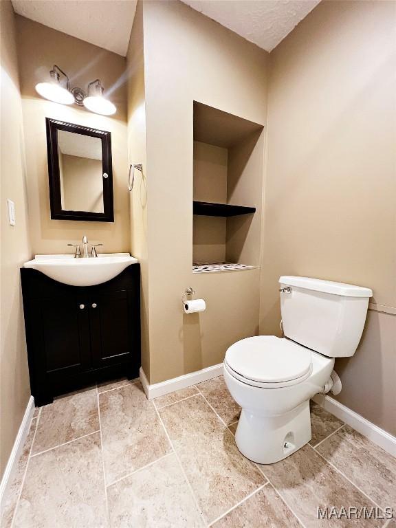 733 Cartwright Rd, Titus, AL 36080 - bathroom with vanity, toilet, and baseboards