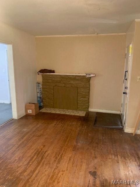 unfurnished living room featuring ornamental molding, a fireplace, wood finished floors, and baseboards
