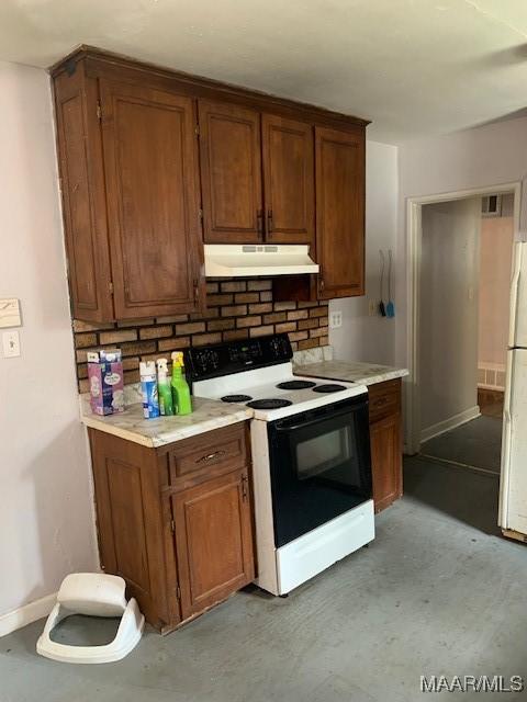 kitchen featuring brown cabinets, light countertops, baseboards, under cabinet range hood, and range with electric stovetop