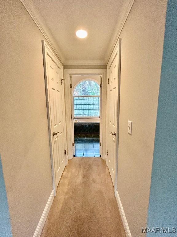 hall with ornamental molding, a textured ceiling, carpet, and baseboards