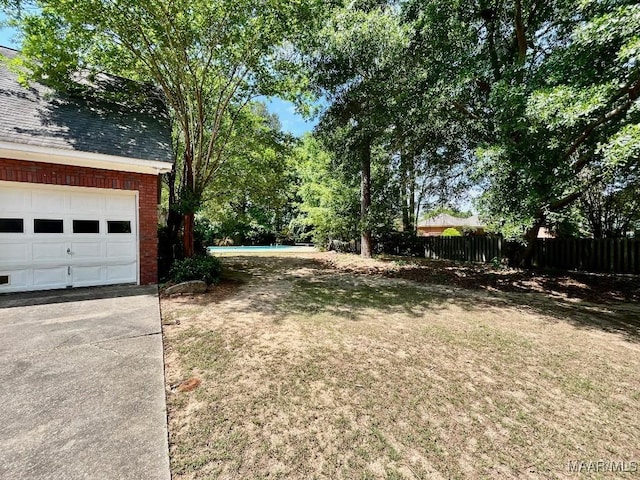 view of yard with a garage and fence