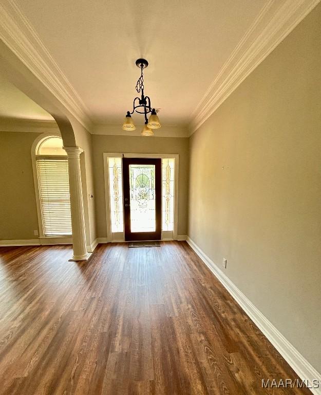 foyer with a chandelier, baseboards, ornate columns, and dark wood-style flooring