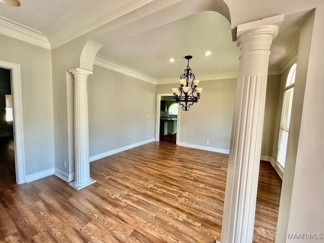 unfurnished dining area with decorative columns, wood finished floors, and plenty of natural light