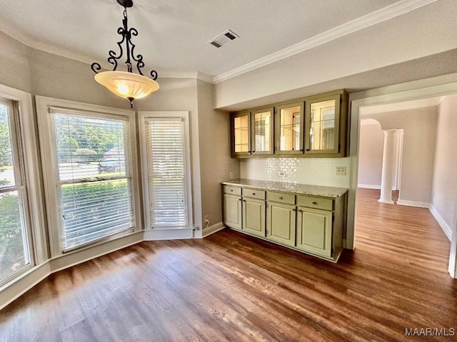 interior space featuring dark wood-style flooring, visible vents, ornamental molding, and baseboards