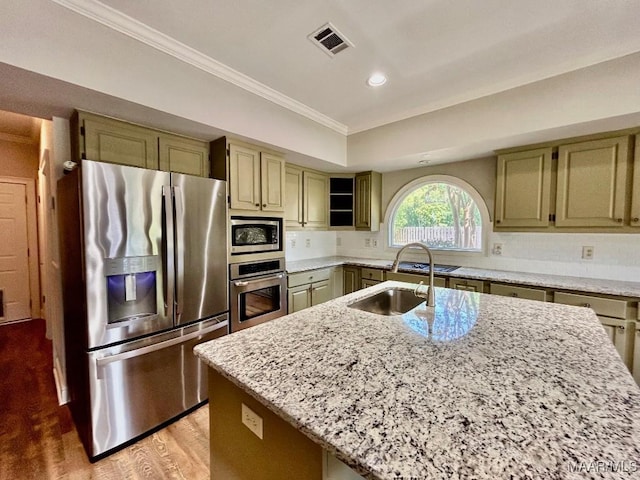 kitchen with a sink, visible vents, light stone counters, ornamental molding, and appliances with stainless steel finishes