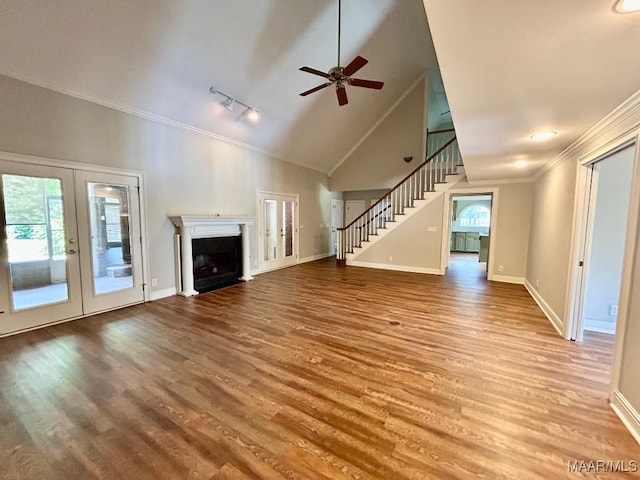 unfurnished living room featuring french doors, crown molding, baseboards, and stairs