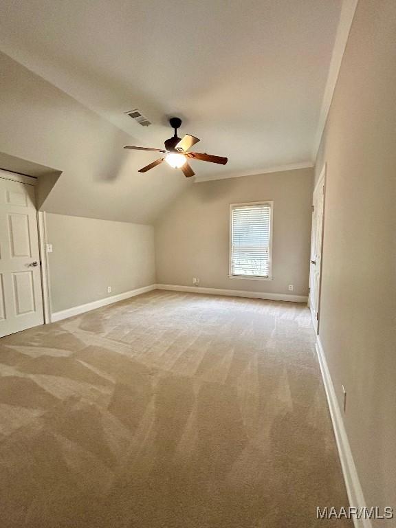 additional living space with visible vents, a ceiling fan, baseboards, and light carpet