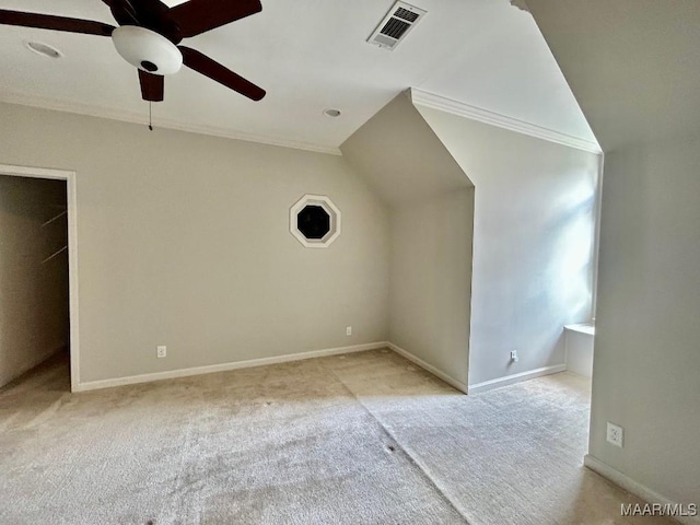 additional living space featuring ceiling fan, lofted ceiling, visible vents, baseboards, and light colored carpet