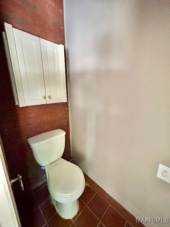 bathroom with tile patterned floors, toilet, and baseboards