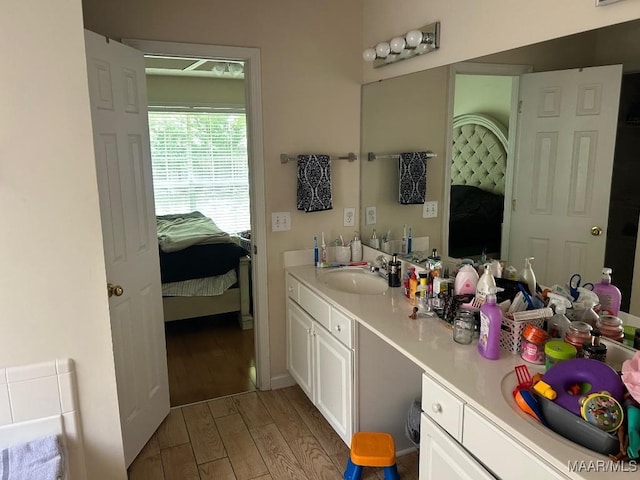 ensuite bathroom with wood finished floors, ensuite bathroom, and vanity