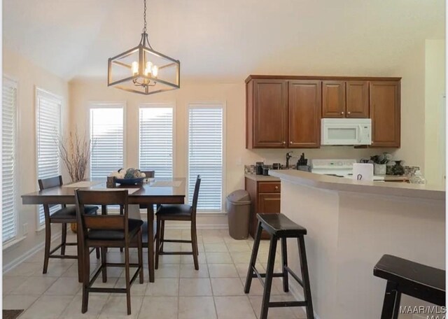 7648 Steele Ridge Dr, Montgomery, AL 36117 - dining area with a chandelier, baseboards, light tile patterned floors, and vaulted ceiling