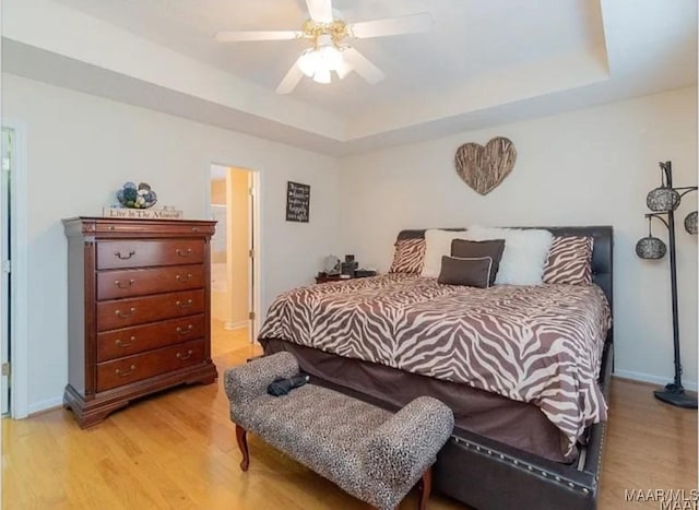 7648 Steele Ridge Dr, Montgomery, AL 36117 - bedroom featuring a raised ceiling, light wood finished floors, a ceiling fan, and baseboards