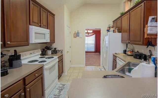 7648 Steele Ridge Dr, Montgomery, AL 36117 - kitchen featuring white appliances, vaulted ceiling, light countertops, light tile patterned flooring, and a sink