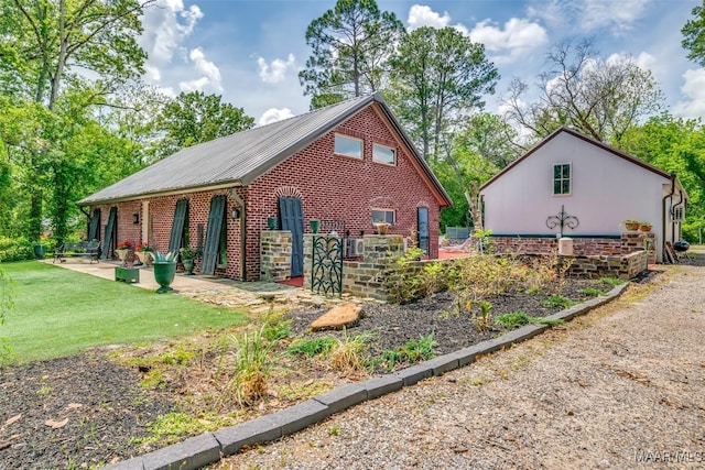 view of side of home with brick siding and a lawn