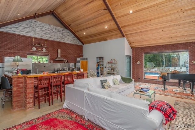 living room with finished concrete floors, wood ceiling, high vaulted ceiling, and brick wall