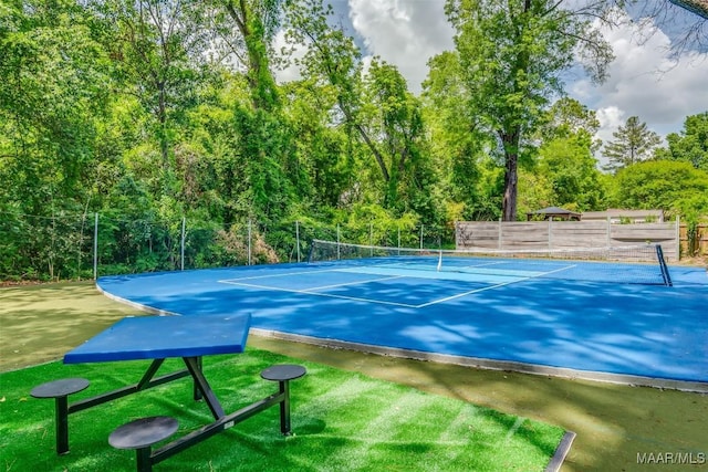 view of tennis court featuring fence