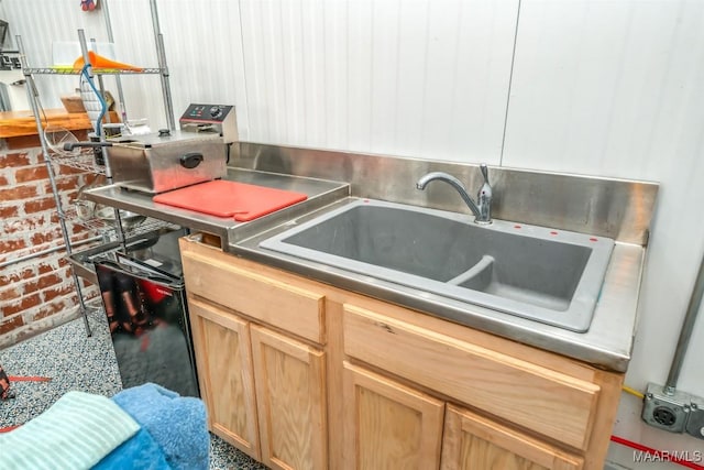 interior space with light brown cabinetry and a sink