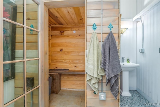 bathroom featuring a sink, baseboards, and wood ceiling