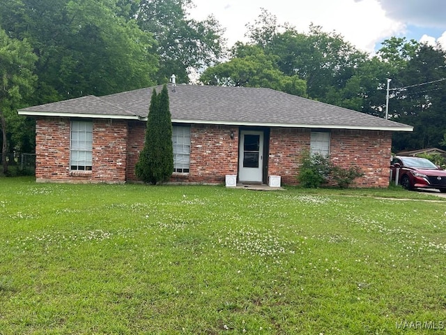 single story home with brick siding, a shingled roof, and a front yard